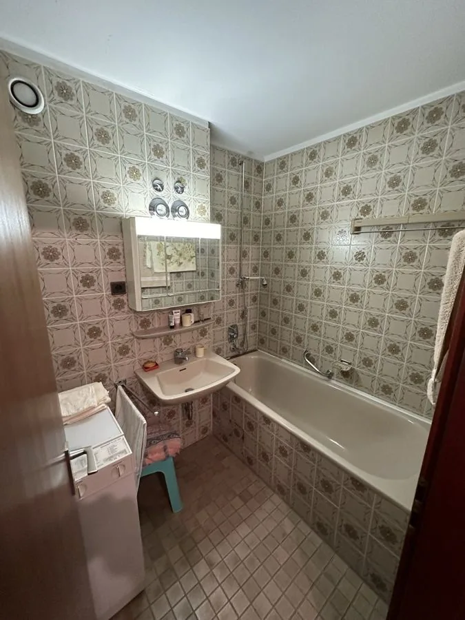 Bad vor der Sanierung mit Blümchenfliesen und alter Wanne
